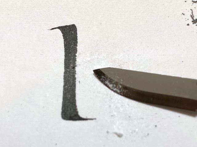 スカルペルナイフで紙の表面を滑らかにしている